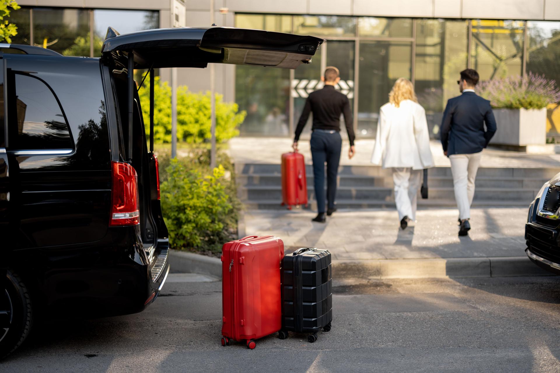 Driver helps a business couple carry their suitcases to the office or hotel